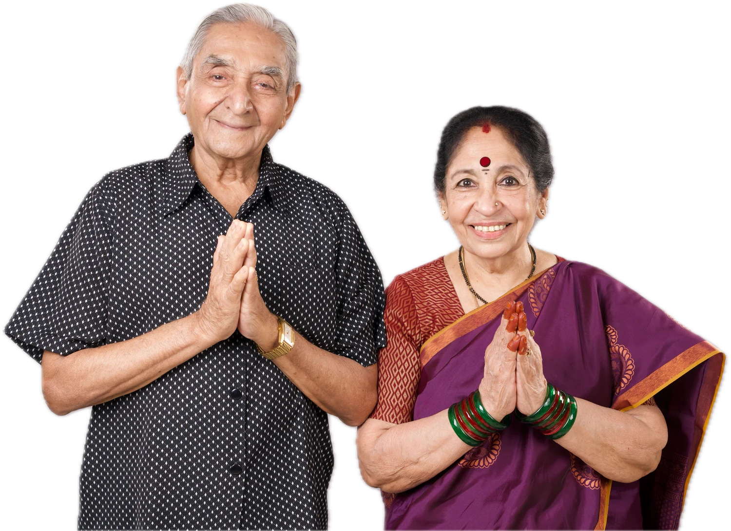 A senior couple welcoming guests with a namaste, in front of Harmonia Pavilion